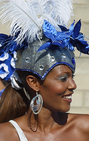 Barranquilla Carnival Dancer in Blue and Silver Headdress Smiling Afro-Colombian woman wearing a glittering blue and silver headdress adorned with feathers and jewels, performing during the Barranquilla Carnival parade