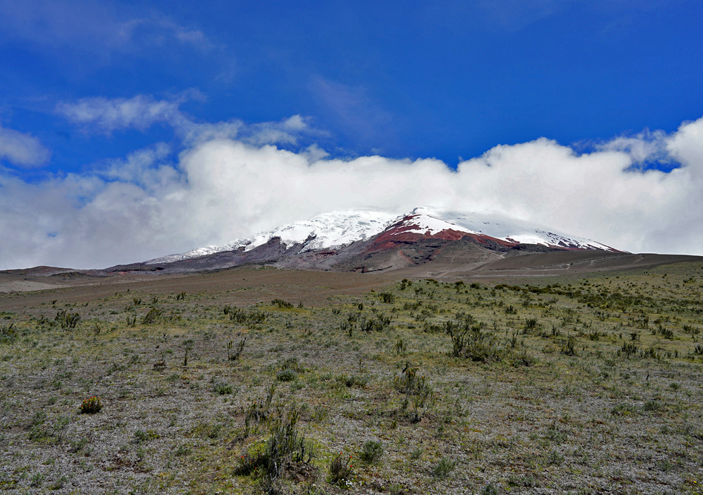 Cotopaxi Volcano Viewed from Afar in the Andes Cotopaxi Volcano towers over a patchwork of agricultural land and rolling hills in Ecuador’s high-altitude páramo, seen from a distant vantage