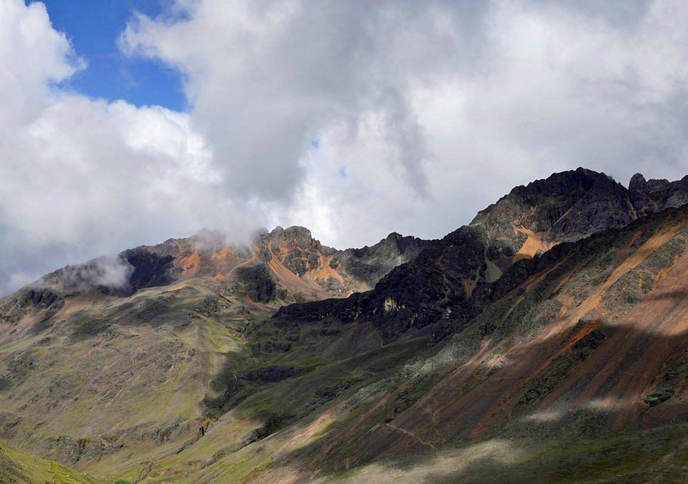 Orange Mountain Andes Isolated cone-shaped peak covered in golden and orange earth tones with surrounding grassy highlands at around 13,000 feet