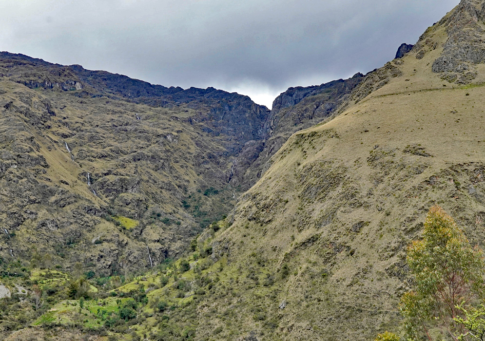 Andes Vilcanota Range Sweeping panorama of the Andes in the Vilcanota range, showing sharp ridges, glacial remnants, and green pastures at high elevation.