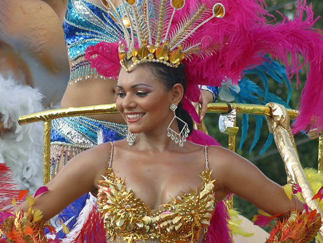 Beautiful Latin woman wearing a gold top in the carnival parade in Barranquilla