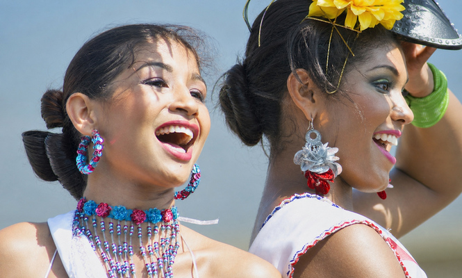 Barranquilla Women Singing at Carnival Two smiling Carnival performers in jeweled costumes sing together during the Barranquilla parade