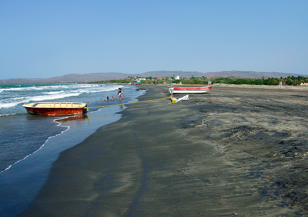 Two boats on the dark colored sands of Playa de Tubará