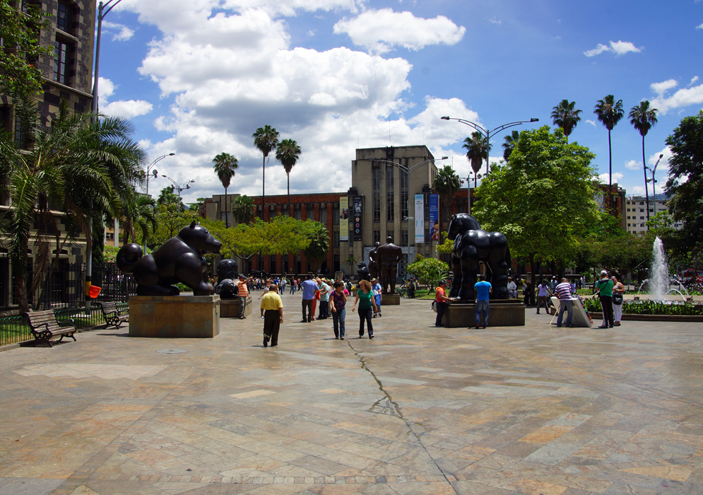 Botero statues in a plaza with a water fountain