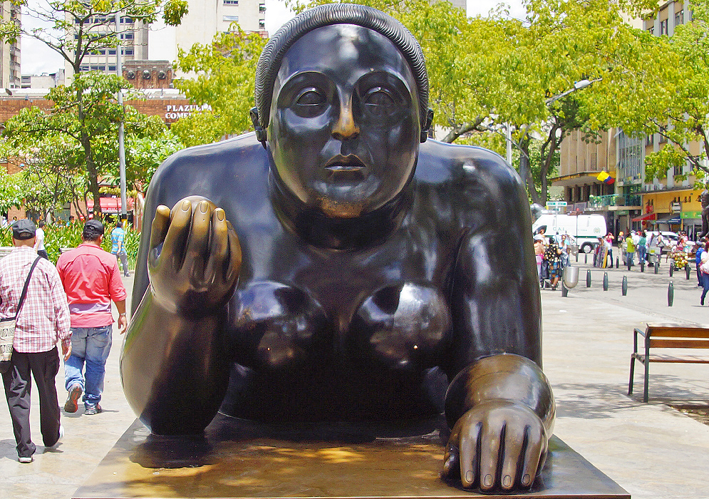 Fat naked woman on her stomach holding a fruit