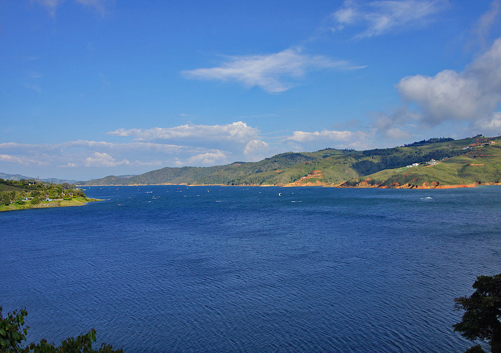 Blue Calima lake with mountains in background 