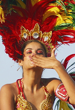 Barranquilla Carnival Performer in Green Feathers Energetic woman wearing a sparkling gold costume and an elaborate green feathered headdress, performing with enthusiasm during the Barranquilla Carnival