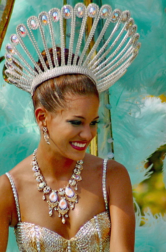 Elegant Barranquilla Carnival dancer wearing a radiant golden costume and ornate silver headdress, smiling during the parade