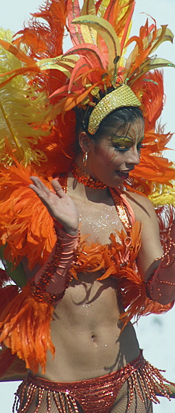 Carnival Dancer in Fiery Orange Costume Colombian woman clapping mid-performance in a dazzling orange feathered costume with gold accents and bold face paint during the Barranquilla Carnival