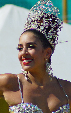 Barranquilla Carnival Queen in Sparkling Crown Smiling woman wearing an ornate jeweled crown and a dazzling costume with crystal embellishments, radiating elegance during the Barranquilla Carnival parade