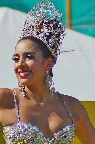 Smiling Barranquilla Carnival queen in jeweled silver crown and shimmering outfit during the parade