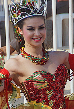 Barranquilla Carnival Queen in Red and Gold Smiling carnival queen wearing a red and gold sequined dress with a beaded necklace and ornate crown during the Barranquilla festivities
