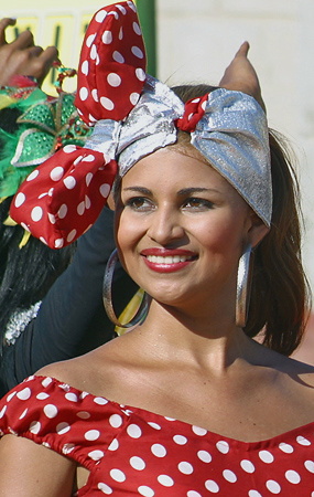 Barranquilla Carnival Dancer in Polka Dot Costume Smiling woman wearing a red and white polka dot dress with a silver and red polka dot headwrap and large hoop earrings during the Barranquilla Carnival parade