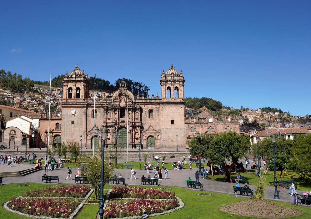 Cusco Cathedral Basilica Peru The Cathedral Basilica of the Assumption in Cusco on a cloudy day, viewed from the plaza with wet cobblestones and green garden paths
