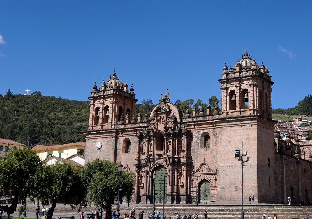 Cusco Cathedral with Blue Sky The Cathedral of Cusco framed by trees and hillside homes, with a bright blue sky in the background