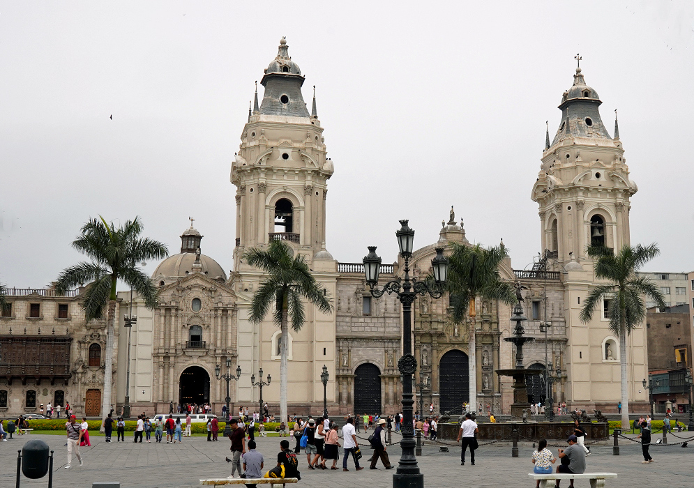 Cathedral Lima Full front view of the Cathedral of Lima with its two towers, palm trees, and crowds of visitors in the central square of the historic center