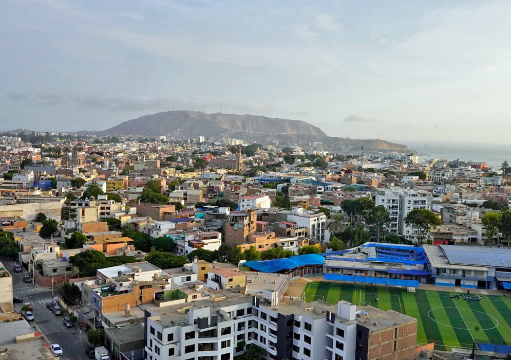 Overlooking Lima from Cerro San Cristóbal Wide shot of Lima, Peru from an elevated position showing dense urban neighborhoods and the Pacific Ocean