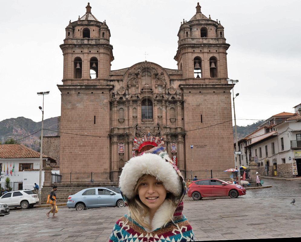 Church of San Pedro Cusco Girl in a colorful Andean poncho standing in front of the Church of San Pedro in Cusco, with its symmetrical bell towers and carved stone entrance