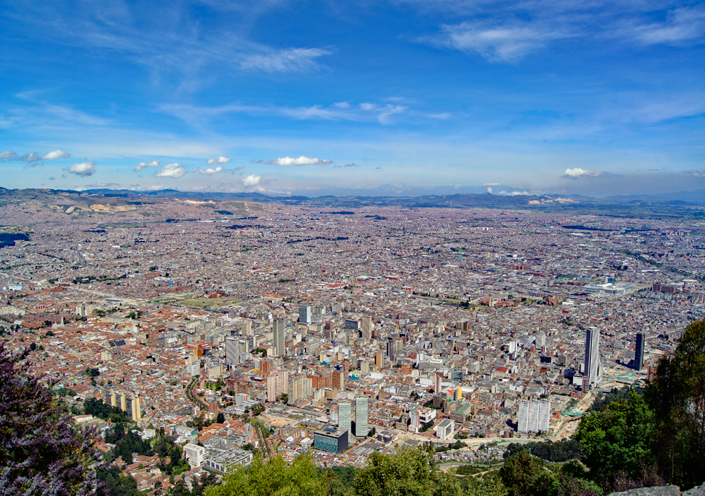A vista of Bogotá under blue skies with a snow-cap mountain in the background