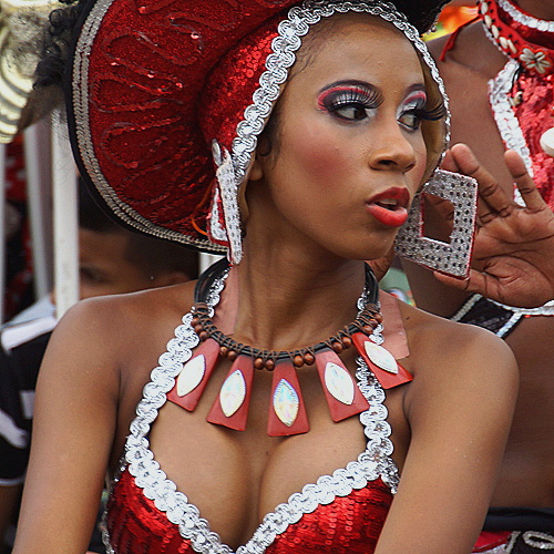 Afro-Colombian Dancer at Barranquilla Carnival Elegant Afro-Colombian woman in a red and silver sequin costume with bold makeup and statement jewelry, turning her head during the Barranquilla Carnival parade
