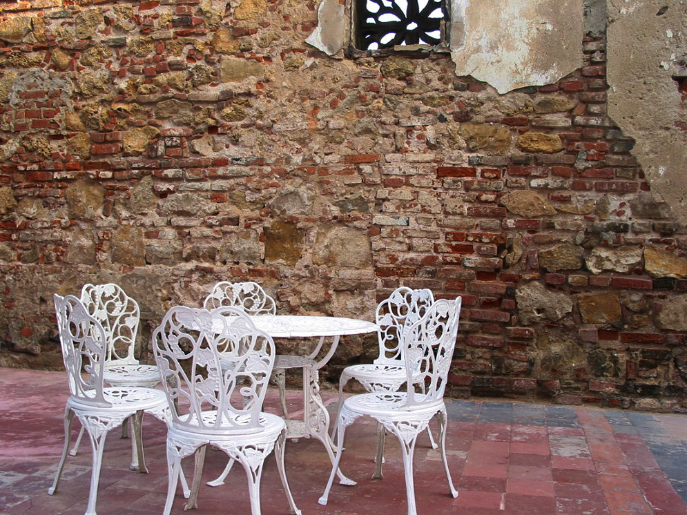 A restaurant with a white table next to an old wall