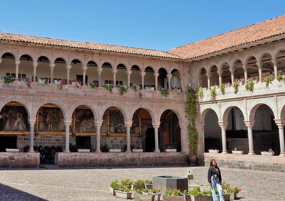 Convent of Santo Domingo Cusco Interior courtyard of the Convent of Santo Domingo in Cusco with colonial arches, flower boxes, and large framed paintings beneath stone archways