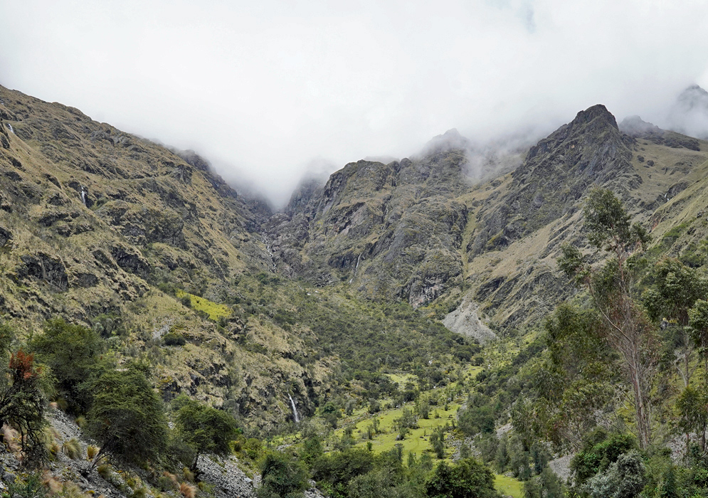 Cordillera Vilcabamba Andes Steep canyon walls and a hidden river valley carved into the Vilcabamba Andes, with scattered trees and isolated farmland visible