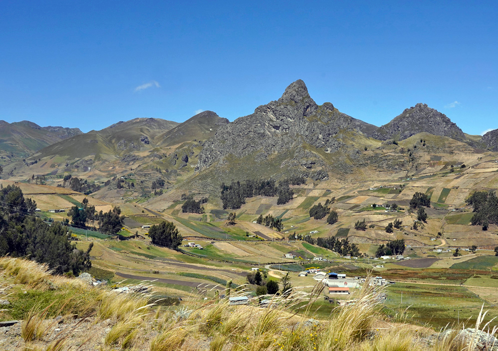 Cotopaxi Andes Farmland View Jagged rocky mountains dominate the skyline above a patchwork of farmland and rural homes in the Andean region of Cotopaxi Province
