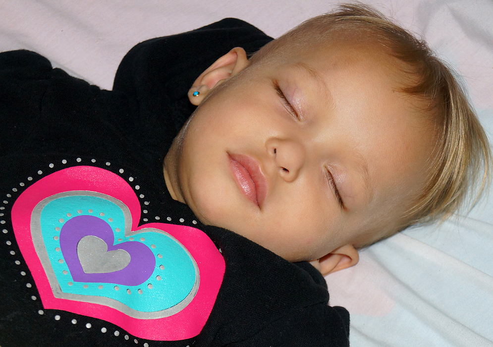 Beautiful one-year-old girl with blonde hair sleeping