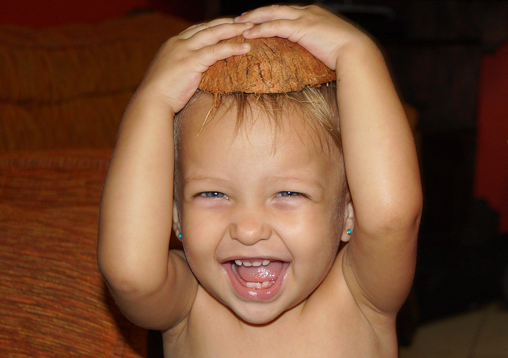Happy one-year-old girl with half a coconut shell on her head