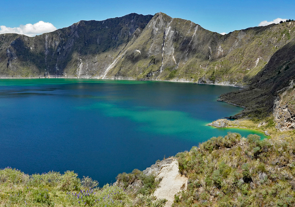 Quilotoa Crater Lake Ecuador vivid blue and turquoise crater lake surrounded by steep volcanic cliffs and páramo vegetation at Quilotoa in the Ecuadorian Andes
