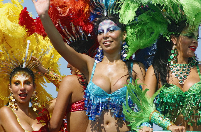 Group of vibrant Colombian women in colorful feathered costumes and sparkling bikinis celebrating during the Barranquilla Carnival