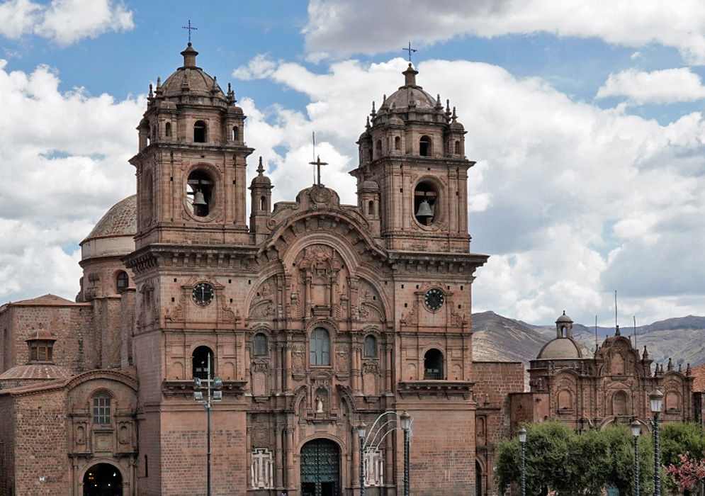 Church of the Society of Jesus Cusco Wide-angle view of the Church of the Society of Jesus in Cusco, Peru, located in Plaza de Armas with a fountain and crowds in the foreground