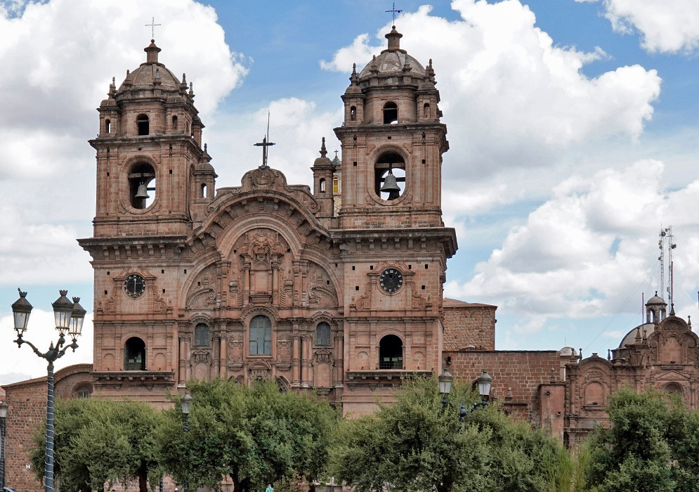 Iglesia de la Compañía de Jesús in Cusco Close-up of Iglesia de la Compañía de Jesús in Cusco with twin bell towers, clock faces, and detailed stone carvings under a partly cloudy sky