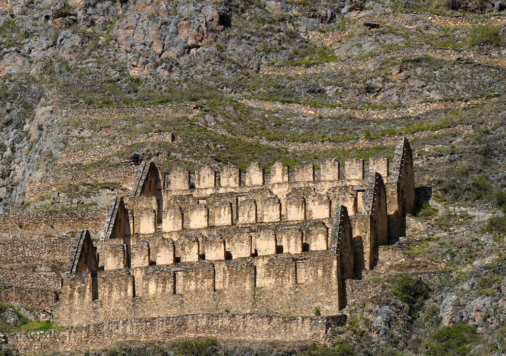 Inca Granaries Pinkuylluna A set of well-preserved Inca granaries built in tiers with trapezoidal niches, perched along a steep rocky slope at Pinkuylluna above the Sacred Valley