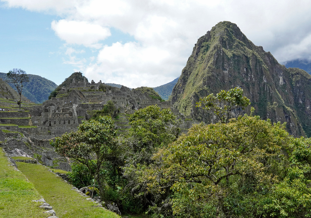 Inca Machu Picchu Ruins Dense stone architecture of Machu Picchu framed by vegetation and dominated by the dramatic peak of Huayna Picchu