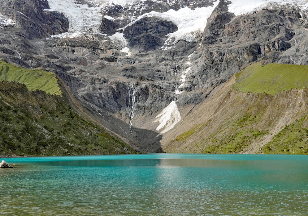 Laguna Humantay Glacial Reflection The turquoise waters of Laguna Humantay reflecting the surrounding steep green slopes and snow-capped cliffs of the Vilcabamba mountain range in the Peruvian Andes