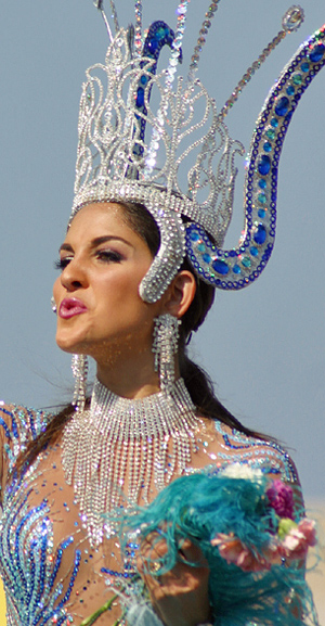 Latina carnival queen wearing an ornate silver and blue jeweled crown and matching outfit during the Barranquilla parade