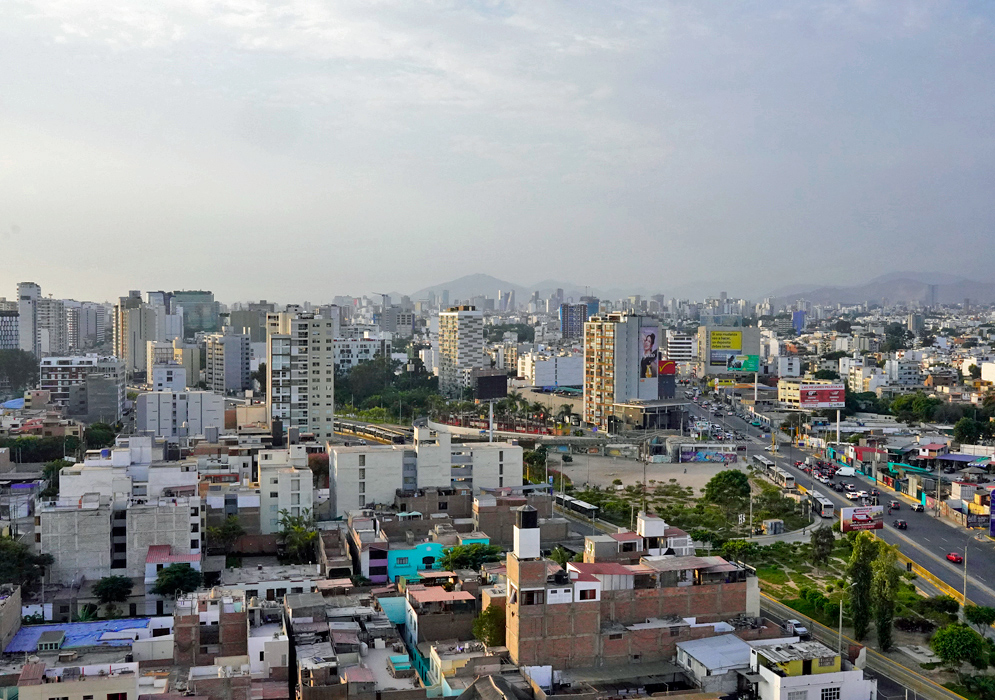 Lima’s Pacific Ocean Coast with Skyline in the Distance Rocky Pacific coastline in Lima with crashing waves and a panoramic view of the distant city skyline