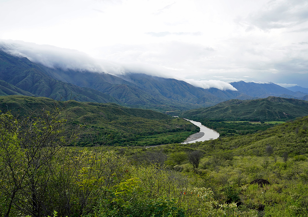 River valley with clouds encroaching the mountains