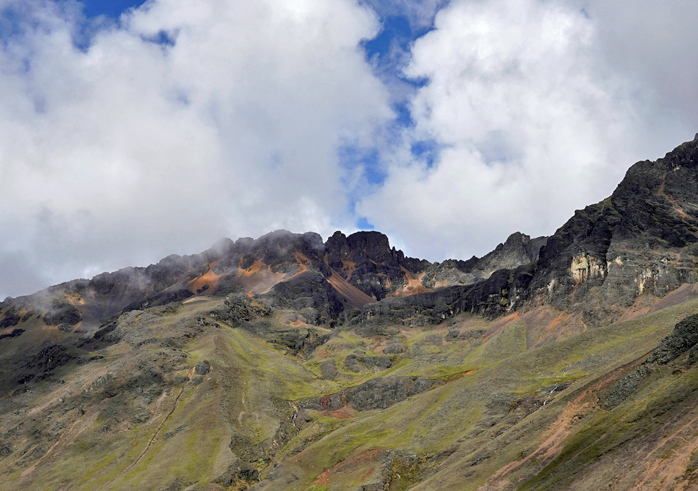 Orange Cordillera Vilcanota Vivid orange and red mineral-stained slopes of the Cordillera Vilcanota highlighted by soft light and framed by cloudy skies