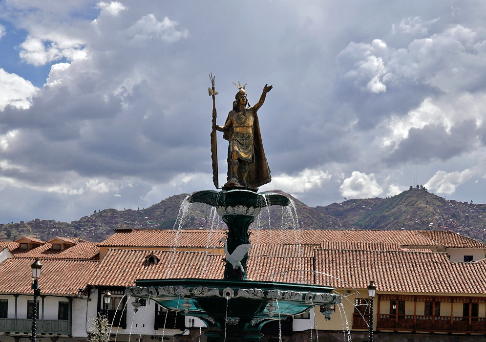 Inca Fountain in Plaza de Armas, Cusco Bronze statue of Inca ruler atop a fountain in Plaza de Armas, Cusco, with Andean hills in the background
