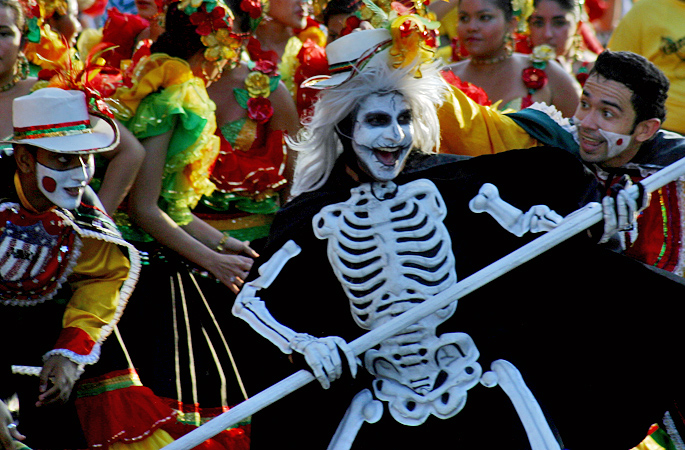 Dancers lead by man wearing a death skeleton custome during Carnival