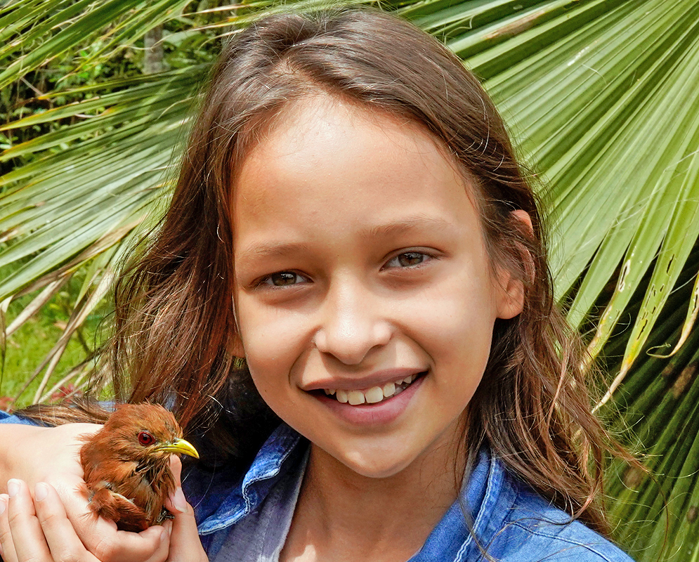 Pretty girl holding a young Piaya cayana in her hand