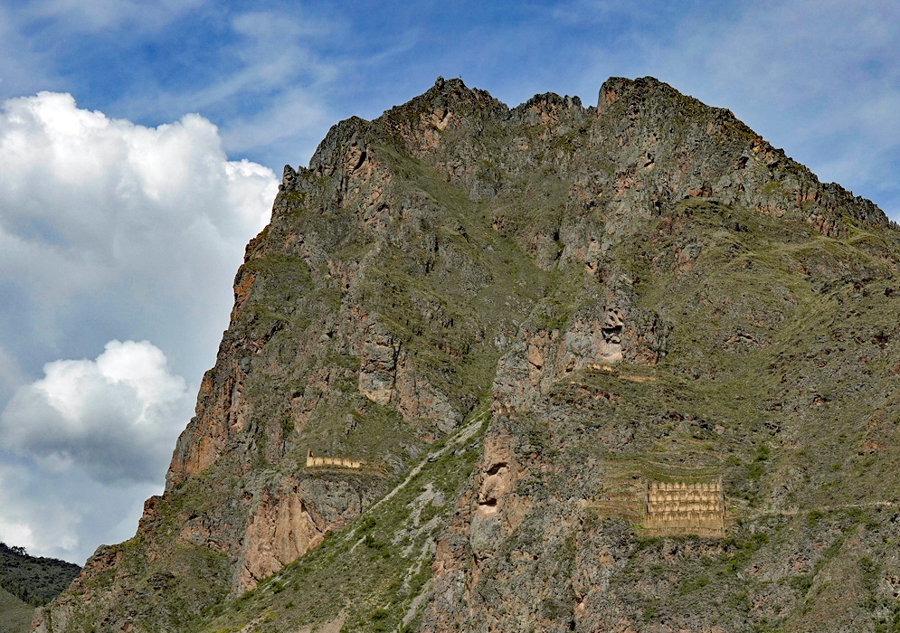 Pinkuylluna Cliff Ruins Two sets of Inca granary ruins built into the side of a towering cliff at Pinkuylluna, surrounded by rugged stone walls and vertical greenery