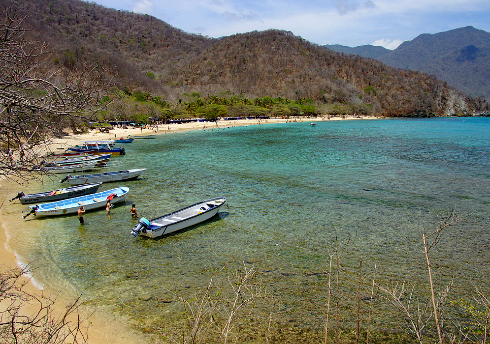 Clear water and small boats anchored on the small cover of Crystal Beach