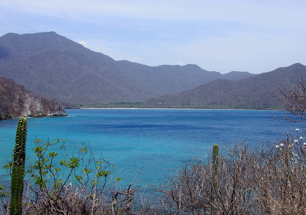 Playa Neguanje Blue Bay Turquoise-blue Playa Neguanje bay bordered by dry coastal hills and cactus-covered scrub