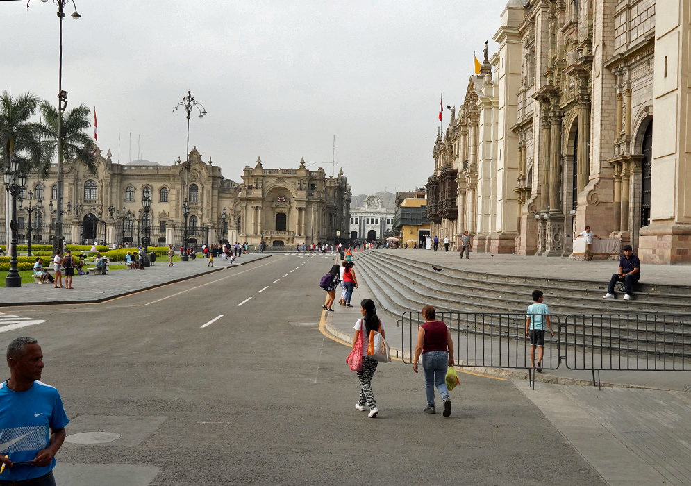 Plaza Mayor Lima Peru View of Plaza Mayor in Lima, Peru, with colonial architecture, palm trees, and people walking along the broad avenue in front of the Government Palace and the Cathedral of Lima