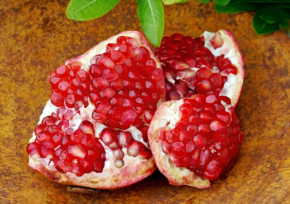 Portions of an open Pomegranade exposing the white membranes and red pulp