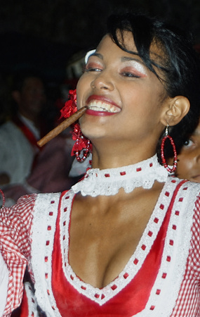 Carnival Performer with Cigar and Red Dress Joyful Colombian woman dressed in a red and white costume with hoop earrings and a cigar in her mouth, smiling during a lively Barranquilla Carnival celebration